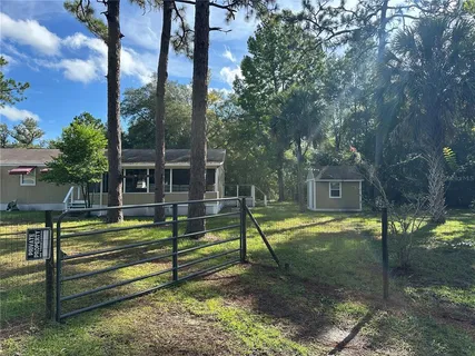 a view of a park with couches and wooden fence