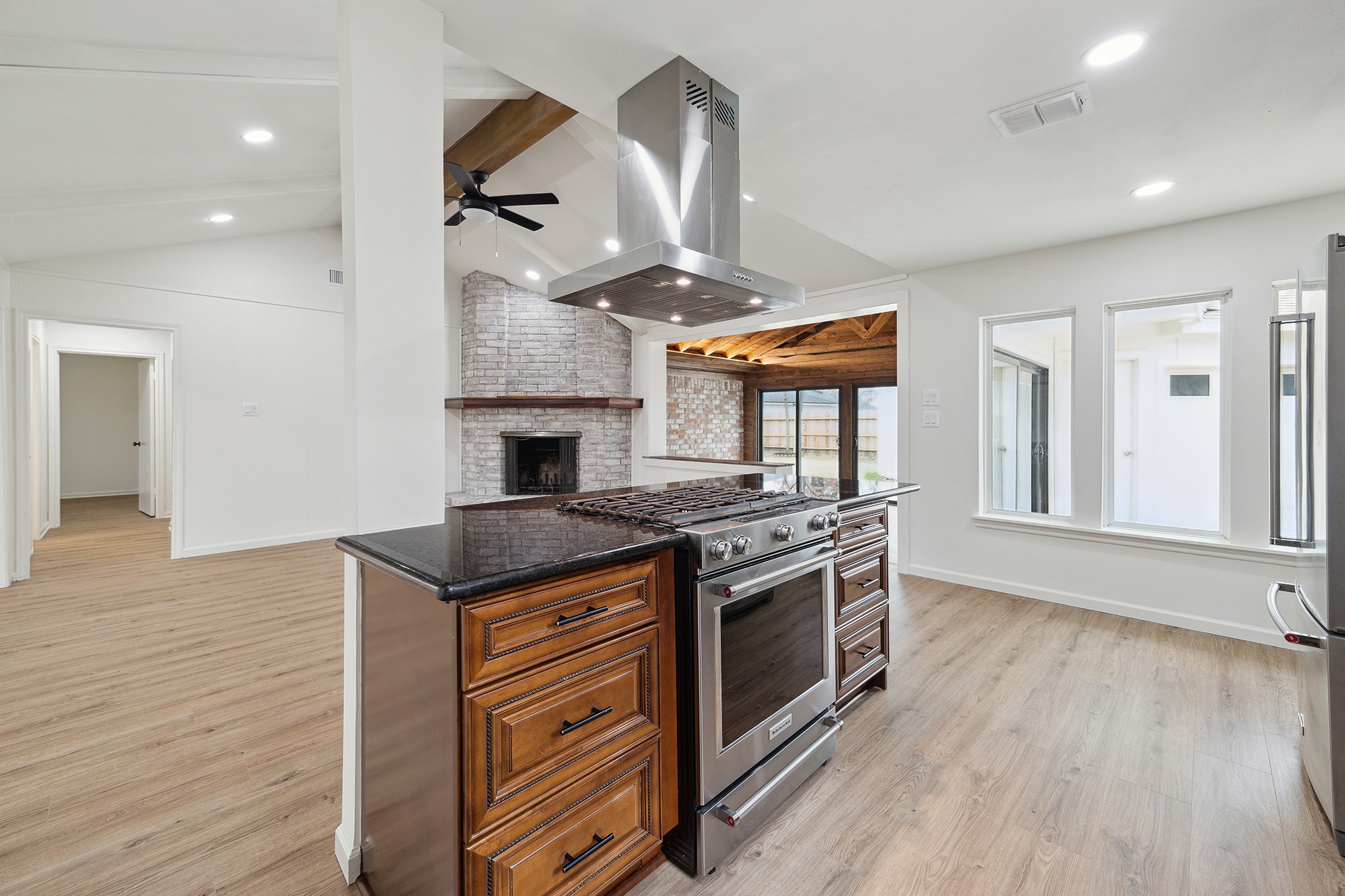 9719 Springmont Drive Houston, TX 77080 - Photo 15 of 32 RECENT gas cooktop is flanked by convenient granite work surfaces and plenty of custom wood cabinetry! Stainless-steel finish appliances throughout appoint this chef's kitchen!!