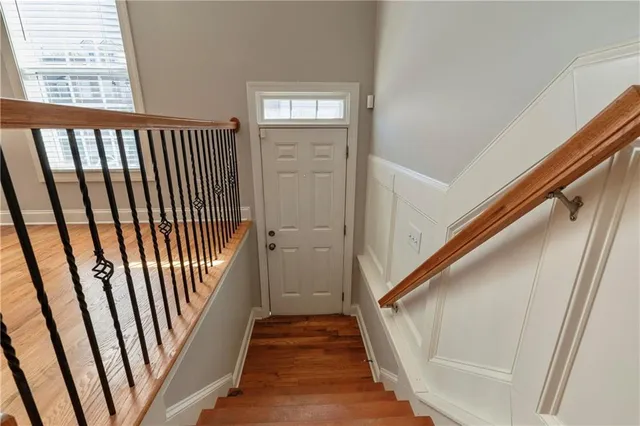 a view of a hallway with wooden floor and staircase