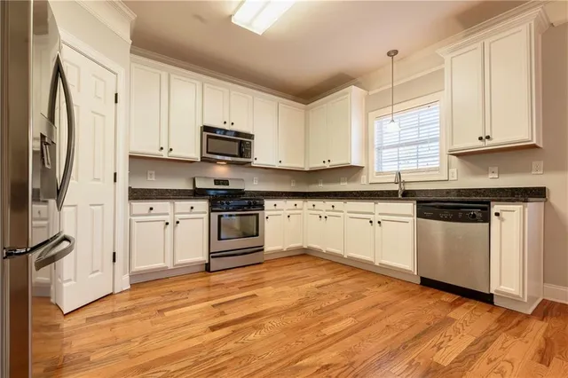 a kitchen with granite countertop white cabinets and white appliances