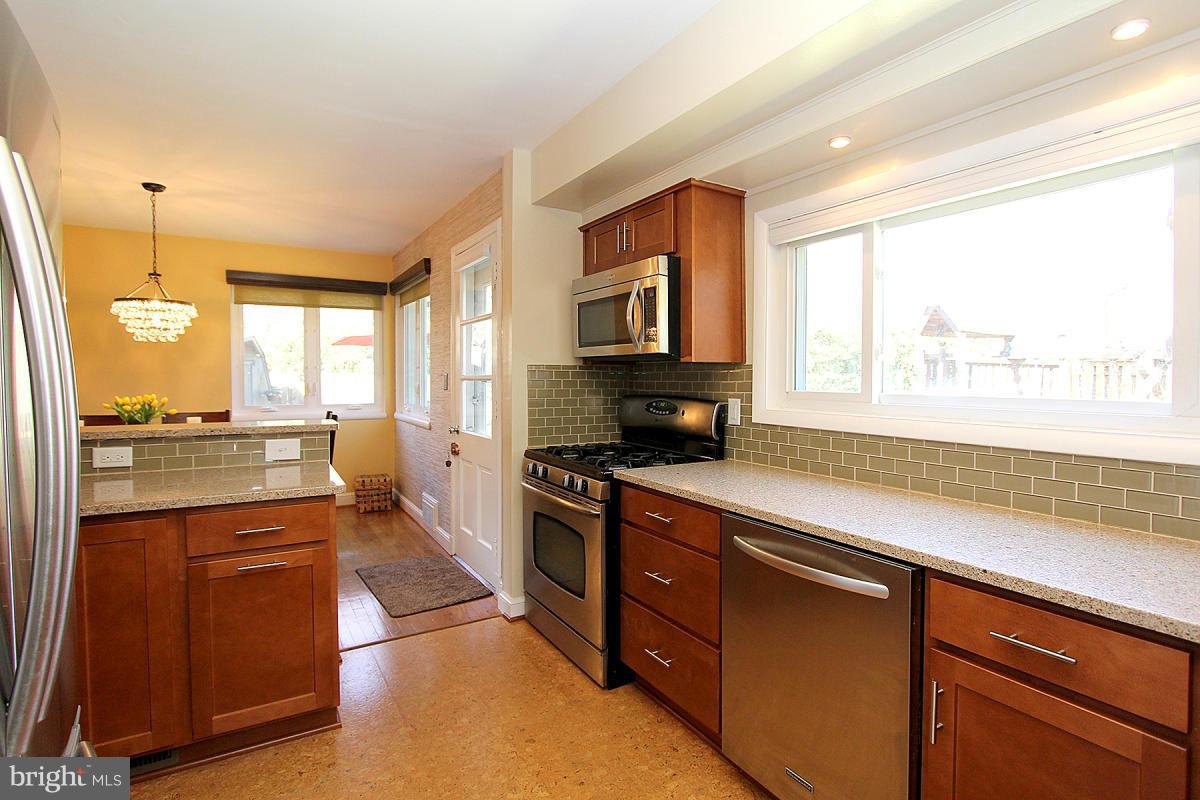 109 Belton Road Silver Spring, MD 20901 - Photo 11 of 30 a kitchen with stainless steel appliances granite countertop a stove a sink and a refrigerator