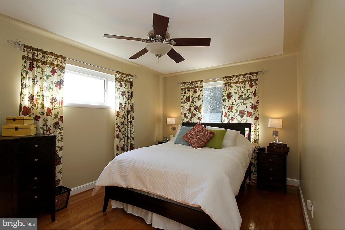 109 Belton Road Silver Spring, MD 20901 - Photo 16 of 30 a bedroom with a large bed and a chandelier
