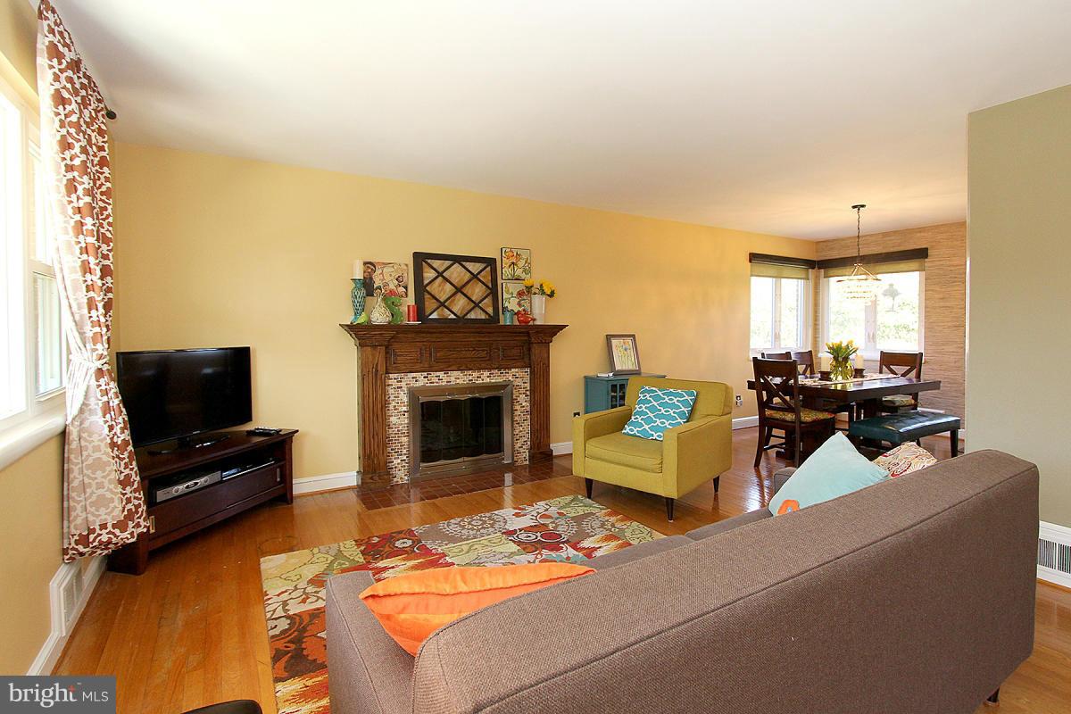 109 Belton Road Silver Spring, MD 20901 - Photo 5 of 30 a living room with furniture a flat screen tv and a fireplace