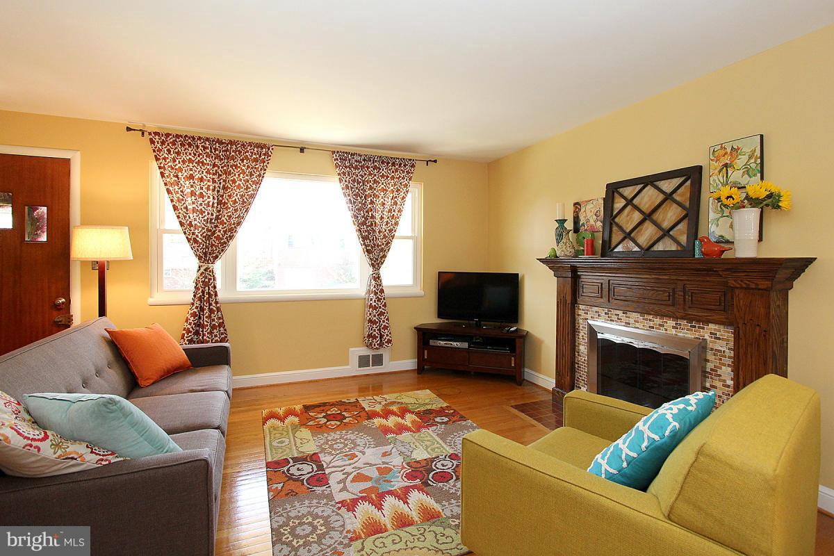 109 Belton Road Silver Spring, MD 20901 - Photo 6 of 30 a living room with furniture a flat screen tv and a fireplace