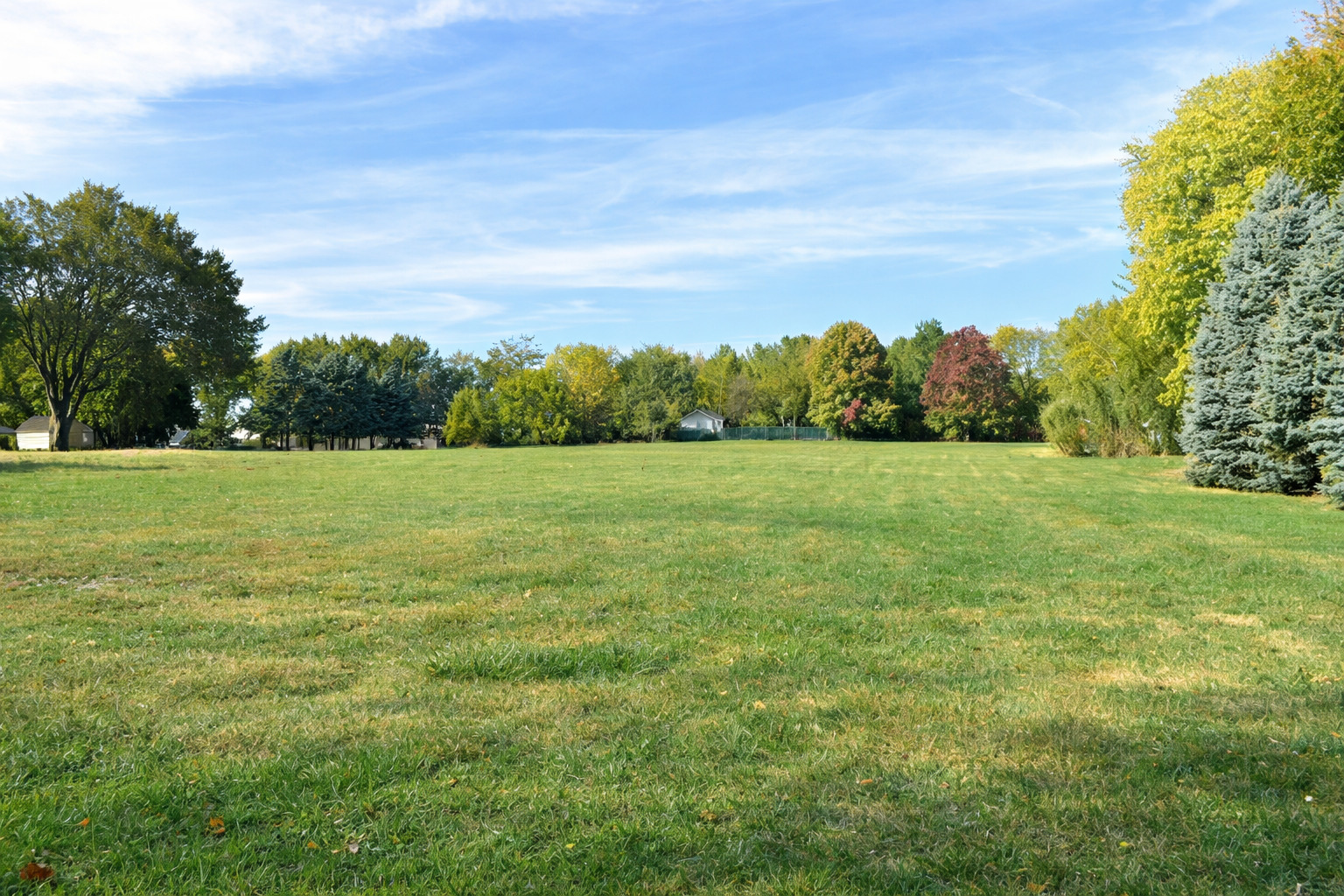 2912 Woodlawn Road Sterling, IL 61081 - Photo 13 of 48 a view of a grassy field with trees in the background