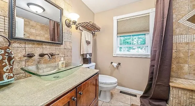 a bathroom with a sink a toilet a mirror and shower
