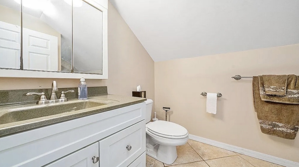 2912 Woodlawn Road Sterling, IL 61081 - Photo 37 of 48 a bathroom with a toilet a sink and a mirror