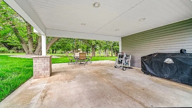 a view of a patio with a table and chairs next to a yard