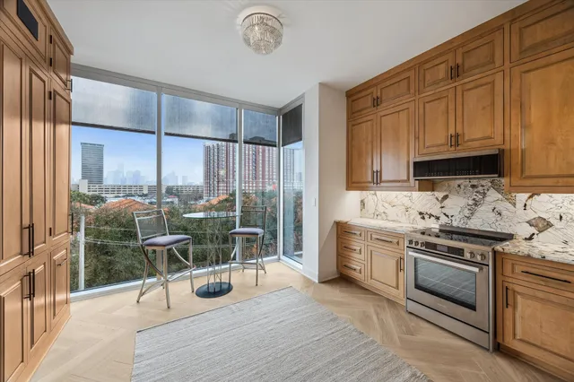 a kitchen with stainless steel appliances granite countertop a stove top oven a sink and white cabinets