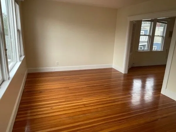 wooden floor in an empty room with a window