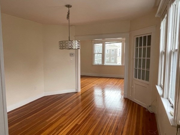 95 Allston Street, Unit 3 Cambridge, MA 02139 - Photo 4 of 12 a view of empty room with wooden floor and fan