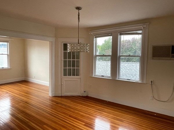 95 Allston Street, Unit 3 Cambridge, MA 02139 - Photo 5 of 12 a view of an empty room with wooden floor and a window