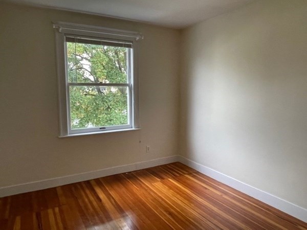 95 Allston Street, Unit 3 Cambridge, MA 02139 - Photo 8 of 12 an empty room with wooden floor and windows