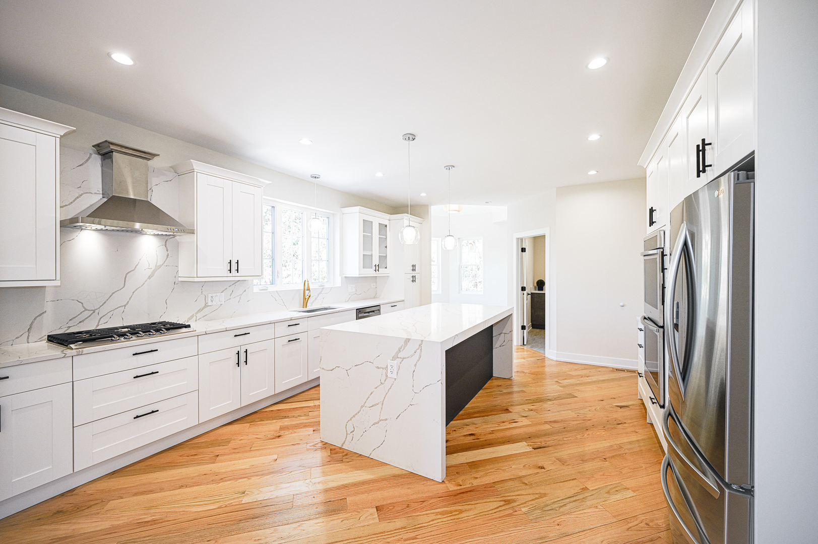 602 Glenshire Road Glenview, IL 60025 - Photo 24 of 98 a large kitchen with stainless steel appliances kitchen island granite countertop a refrigerator a stove a sink dishwasher and white cabinets with wooden floor