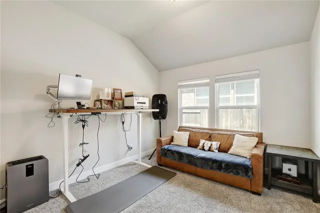 a living room with furniture a window and gym equipment