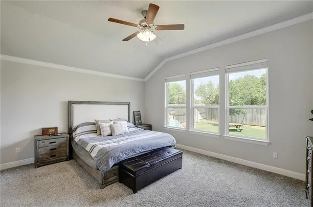 a bedroom with a bed a window and a ceiling fan