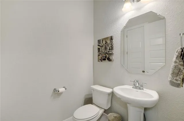 a bathroom with a sink mirror and toilet