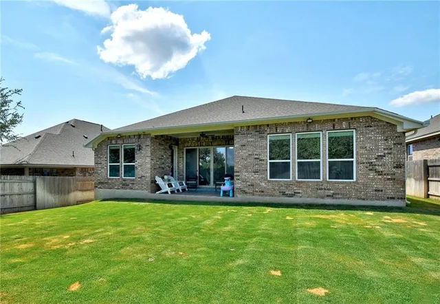 a view of a house with a yard and sitting area
