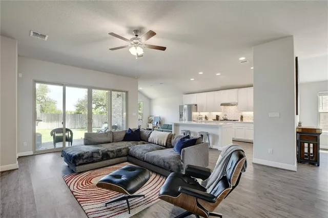 a living room with furniture and kitchen view