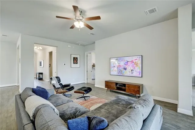 a large living room with stainless steel appliances kitchen island granite countertop furniture and a large window