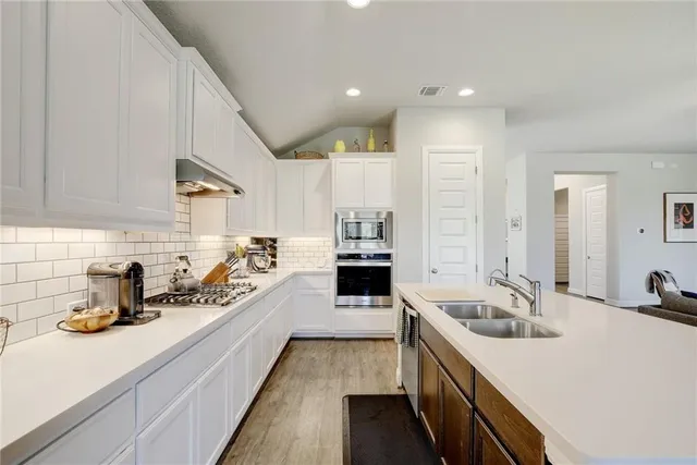 a kitchen with sink stove and cabinets