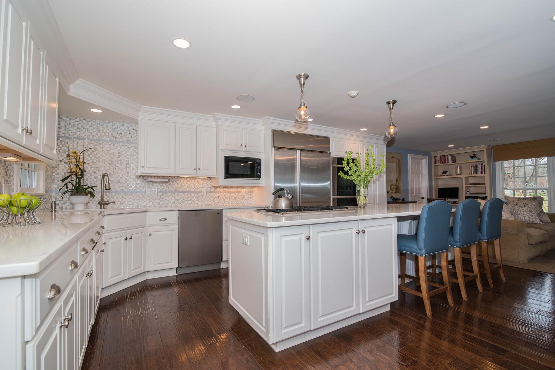 142 Brookside Road Darien, CT 06820 - Photo 8 of 25 a kitchen with stainless steel appliances kitchen island granite countertop a stove top oven a sink a refrigerator with white cabinets and wooden floor