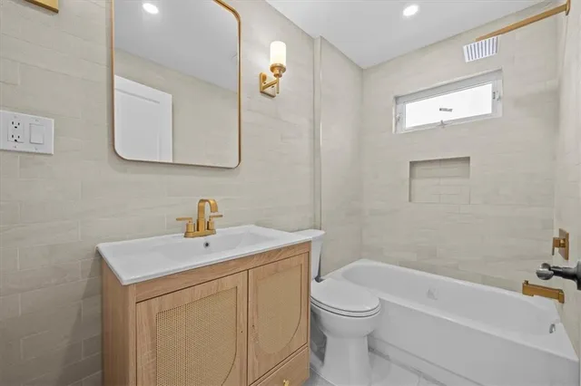 a bathroom with a toilet a sink a mirror and vanity