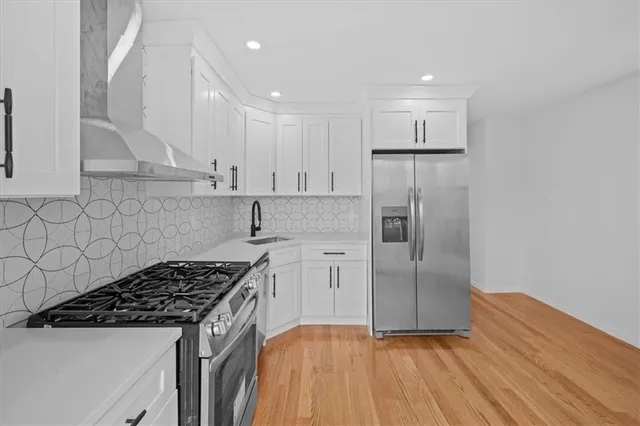 a kitchen with stainless steel appliances granite countertop a stove a refrigerator and a refrigerator