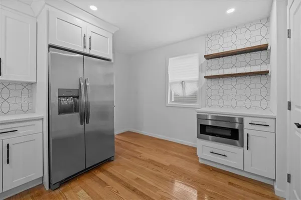 a kitchen with white cabinets and stainless steel appliances