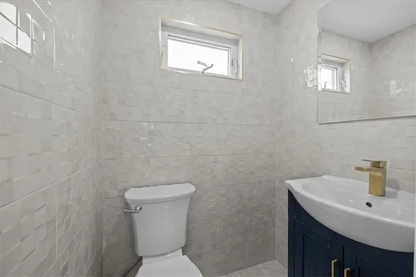 a bathroom with a toilet a sink and mirror