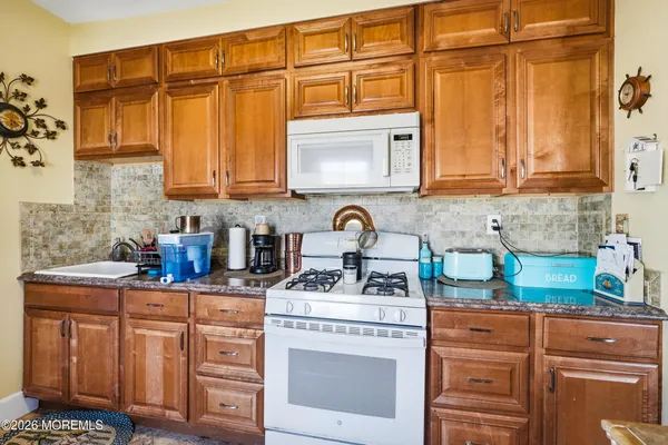 a kitchen with stainless steel appliances granite countertop a sink stove and cabinets