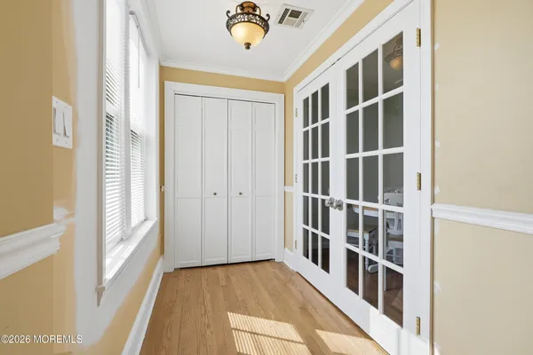 a view of a hallway with wooden floor and entryway