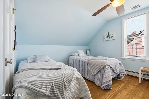 a bedroom with two beds and a window