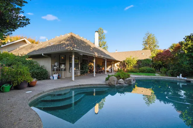 a view of a house with pool yard and sitting area