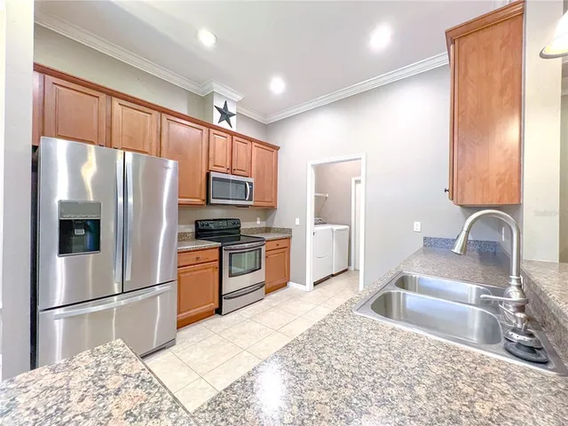 a kitchen with granite countertop a refrigerator and a sink