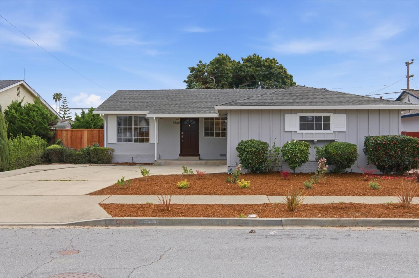 a front view of a house with a yard and potted plants
