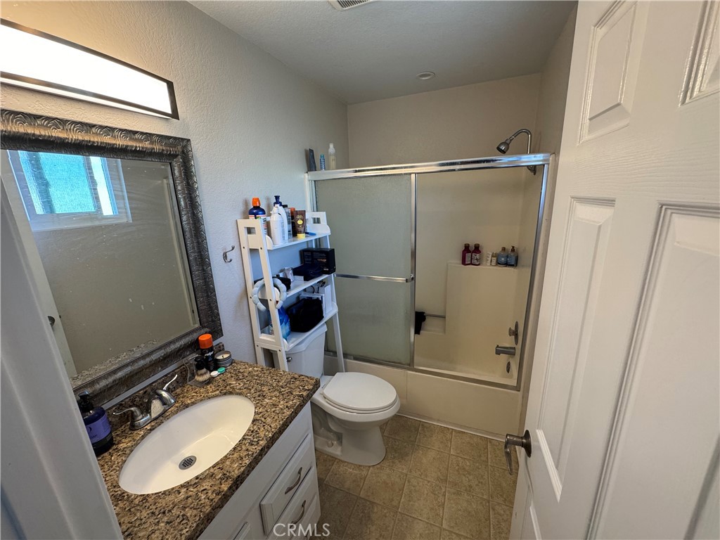 218 Ogle Street, Unit B Costa Mesa, CA 92627 - Photo 8 of 11 a bathroom with a granite countertop sink toilet and shower