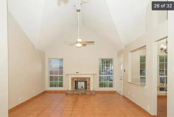 a view of an empty room with a fireplace and a window