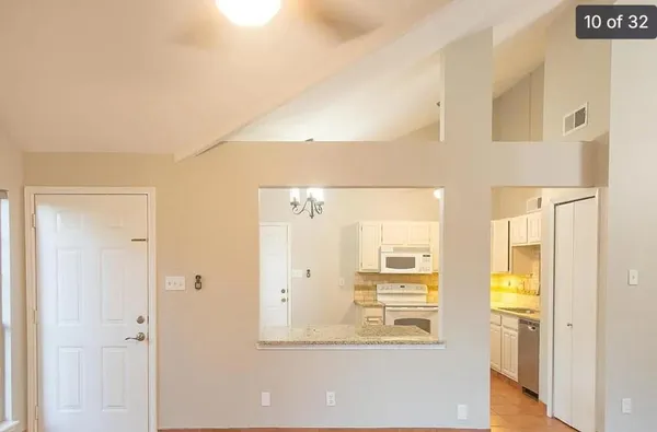 a view of a hallway with wooden floor and a living room