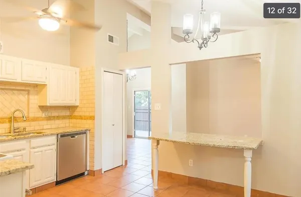 a view of a hallway with wooden floor and a kitchen