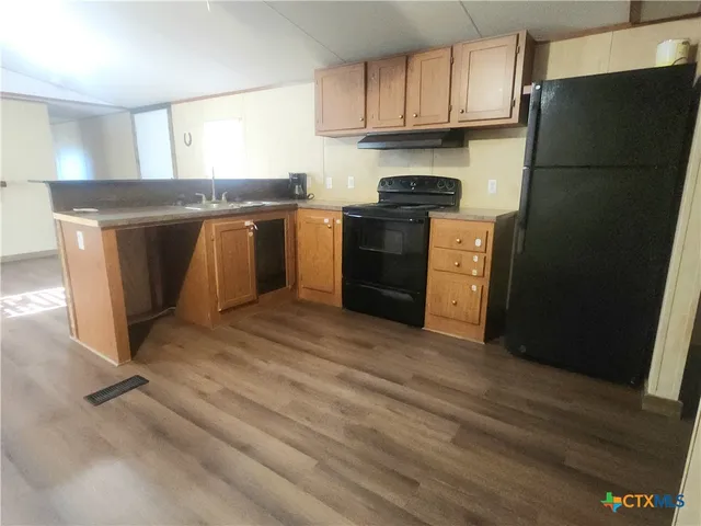 a kitchen with stainless steel appliances granite countertop a refrigerator a stove a sink and a granite counter tops