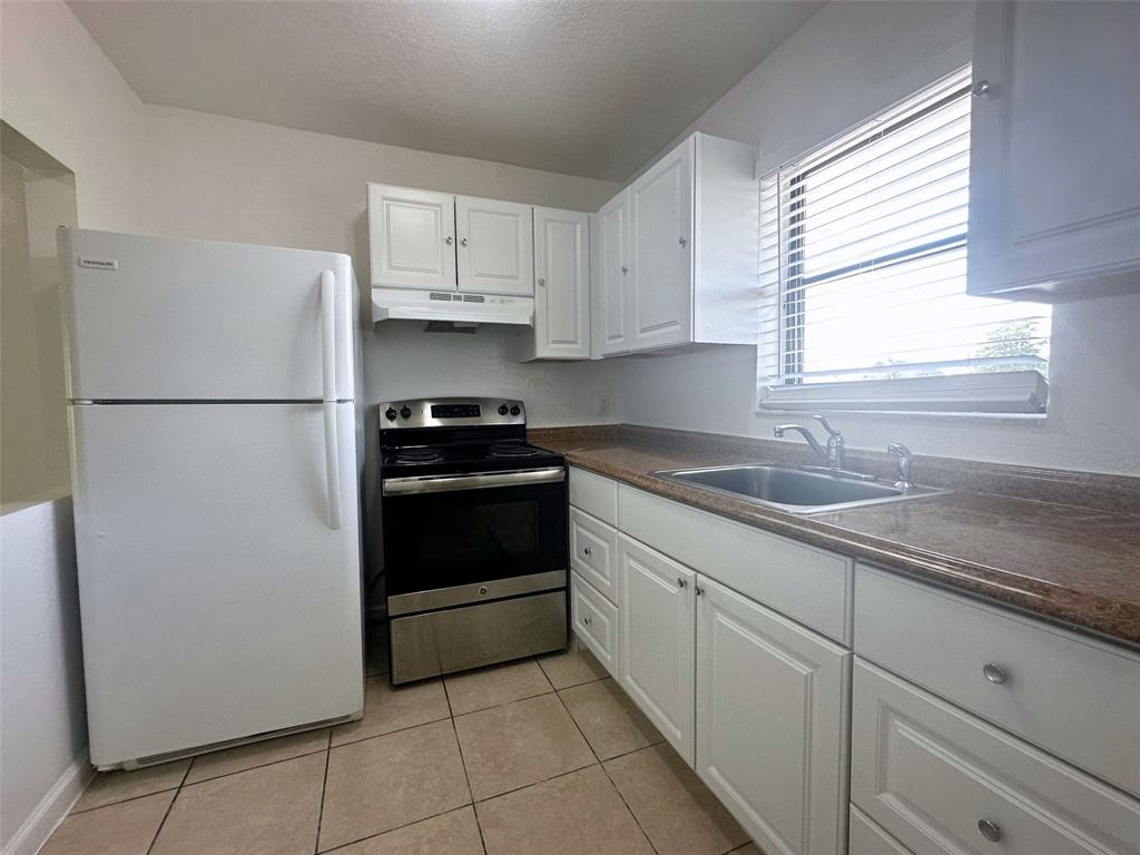 928 South Federal Highway, Unit 20 Lake Worth Beach, FL 33460 - Photo 4 of 12 a kitchen with a refrigerator sink and cabinets