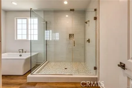 a bathroom with a tub shower sink and mirror