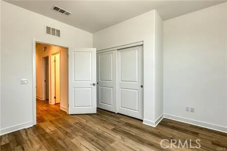 a view of an empty room with closet and a window