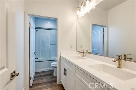 a bathroom with a double vanity sink mirror and toilet