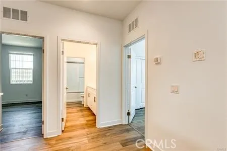 a view of a livingroom with wooden floor and a hallway