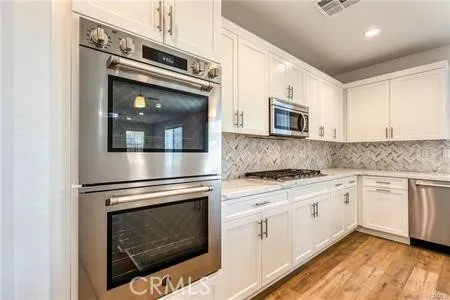 a kitchen with granite countertop white cabinets stainless steel appliances and sink