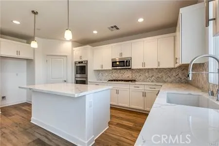 a kitchen with kitchen island a sink stainless steel appliances and cabinets