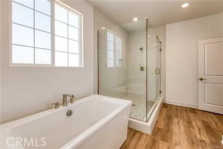 a bathroom with a tub a sink and a large window