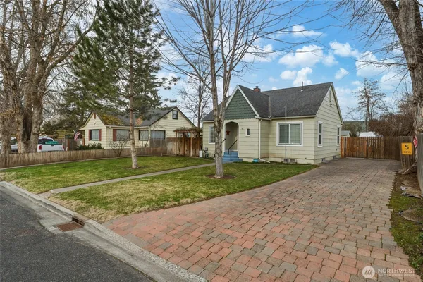 a view of a yard and a house with a large tree